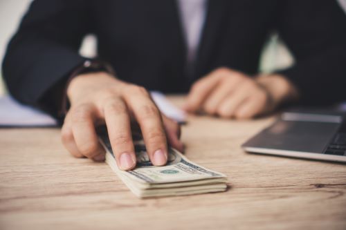 Person sliding money across a table