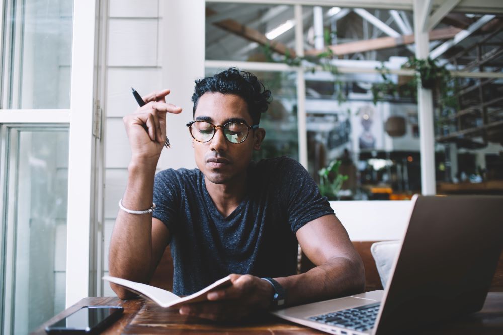 Man looking at open notebook with thoughtful expression