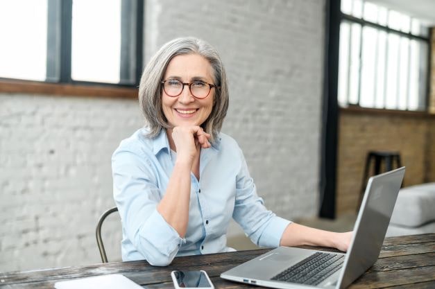 woman in front of her laptop, smiling