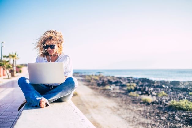 woman working on a laptop at the beach