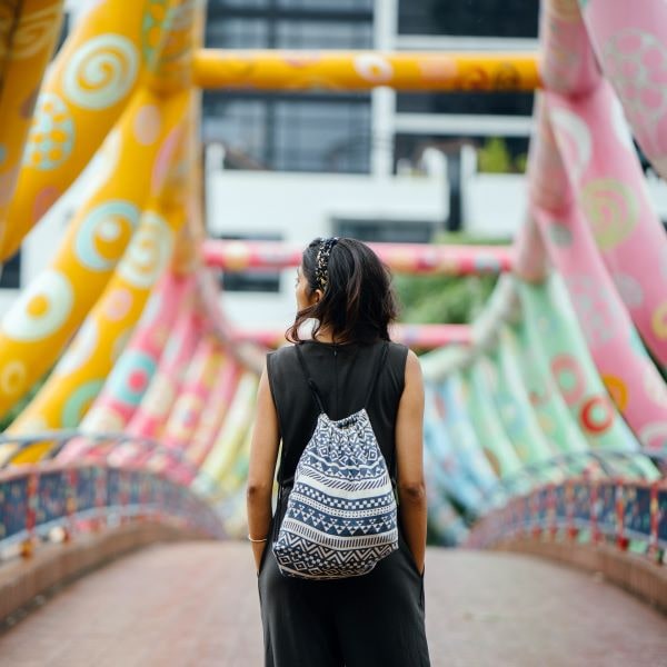 woman crossing colorful urban bridge